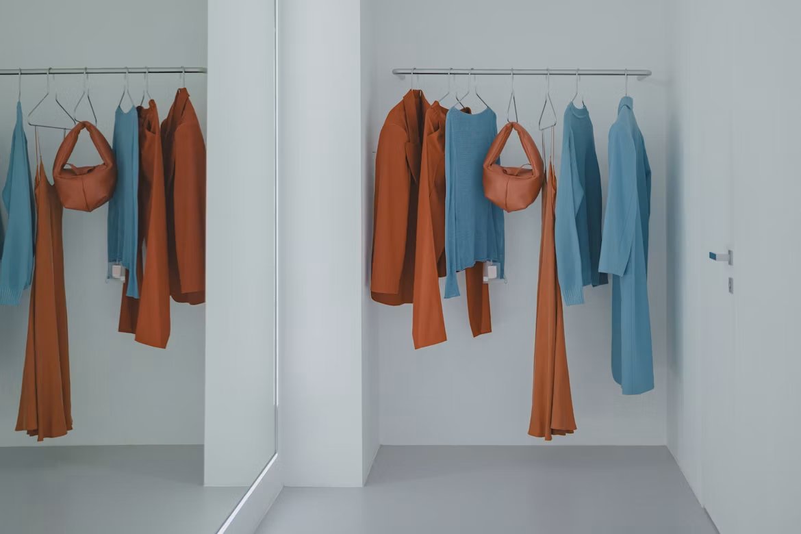 Closet rail with coordinated orange and blue clothing pieces hanging