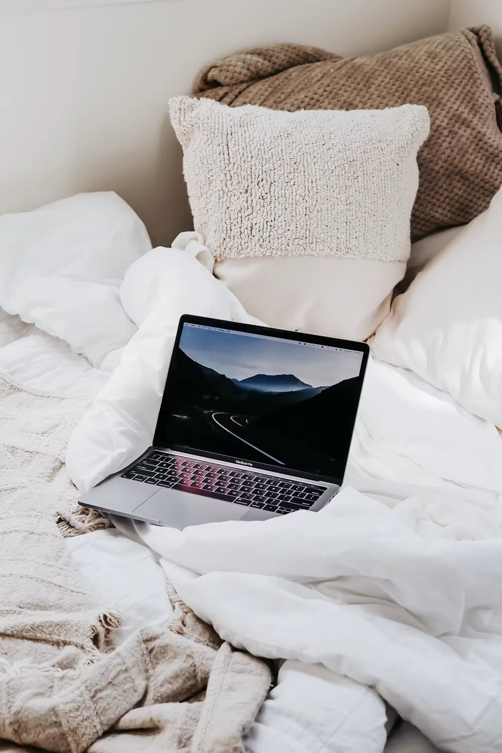 Laptop open on a cozy bed, set up for a virtual styling session
